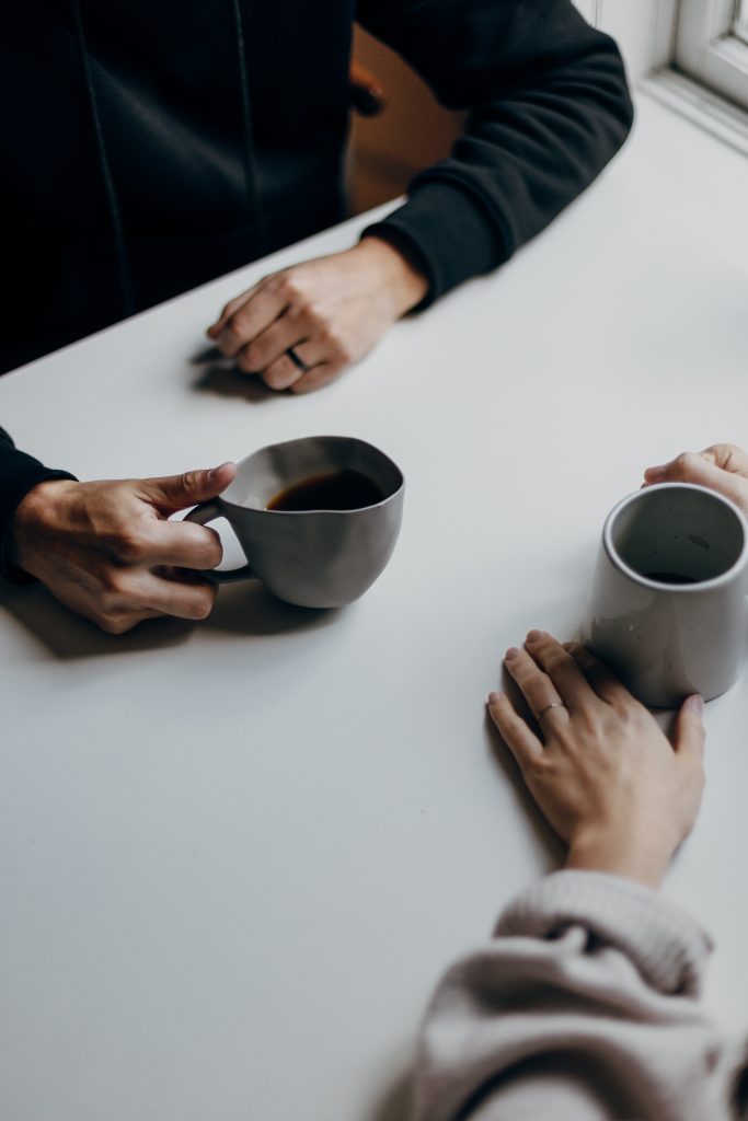 two people holding coffee cups